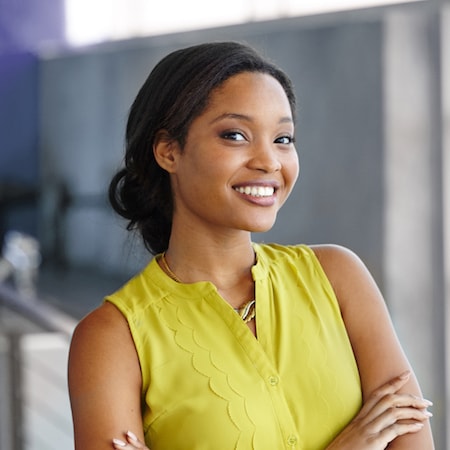 Business woman smiling in a green top after her new dental crowns