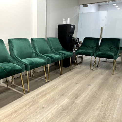 Modern waiting room at Dental Group of Westchester featuring plush green chairs and a beverage station, emphasizing patient comfort and a welcoming environment.