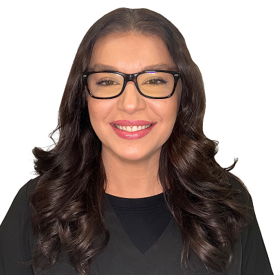 Melvija Hadzovic, dental hygienist at the Dental Group of Westchester, smiling with long hair and glasses, showcasing professionalism and a welcoming demeanor.