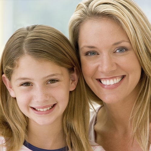 A mother and daughter smiling.