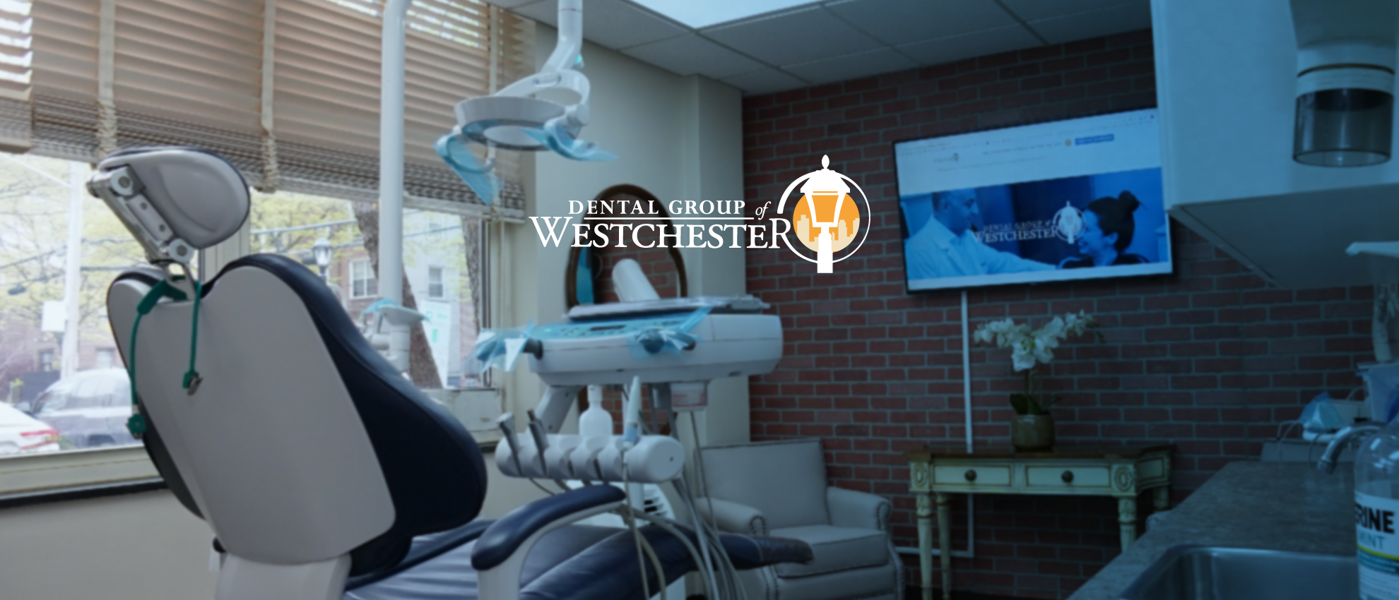 Dental chair and dental equipment in the treatment room of Dental Group of Westchester, featuring a computer screen displaying dental services and a logo, emphasizing advanced periodontal care.